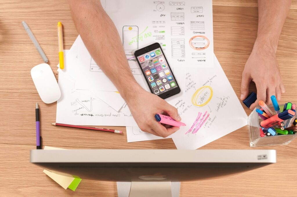 Person writing on white paper with a pen, representing planning or strategy development for brand recognition and SEO success.