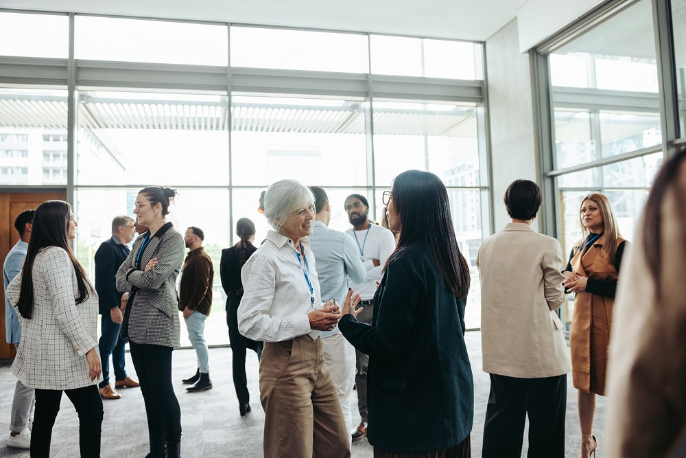 Diverse professionals networking at a business event in a modern office building