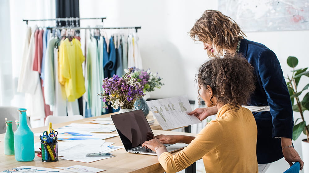 Fashion business owners working improving online visibility